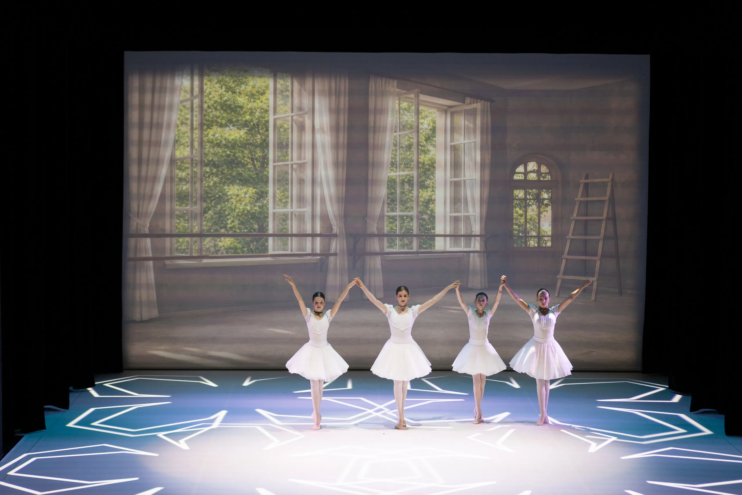 Cinq élèves en tutu blanc, largement cadrées sur le plateau.