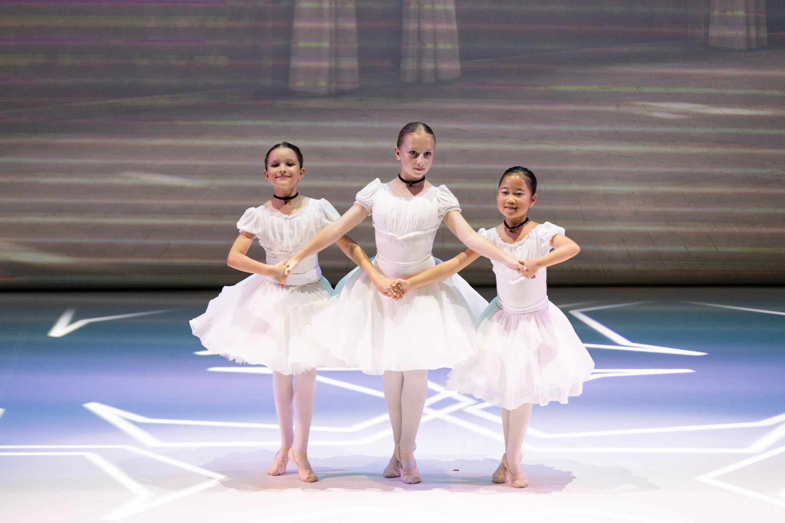 Trois élèves en tutu blanc, lumière naturelle.