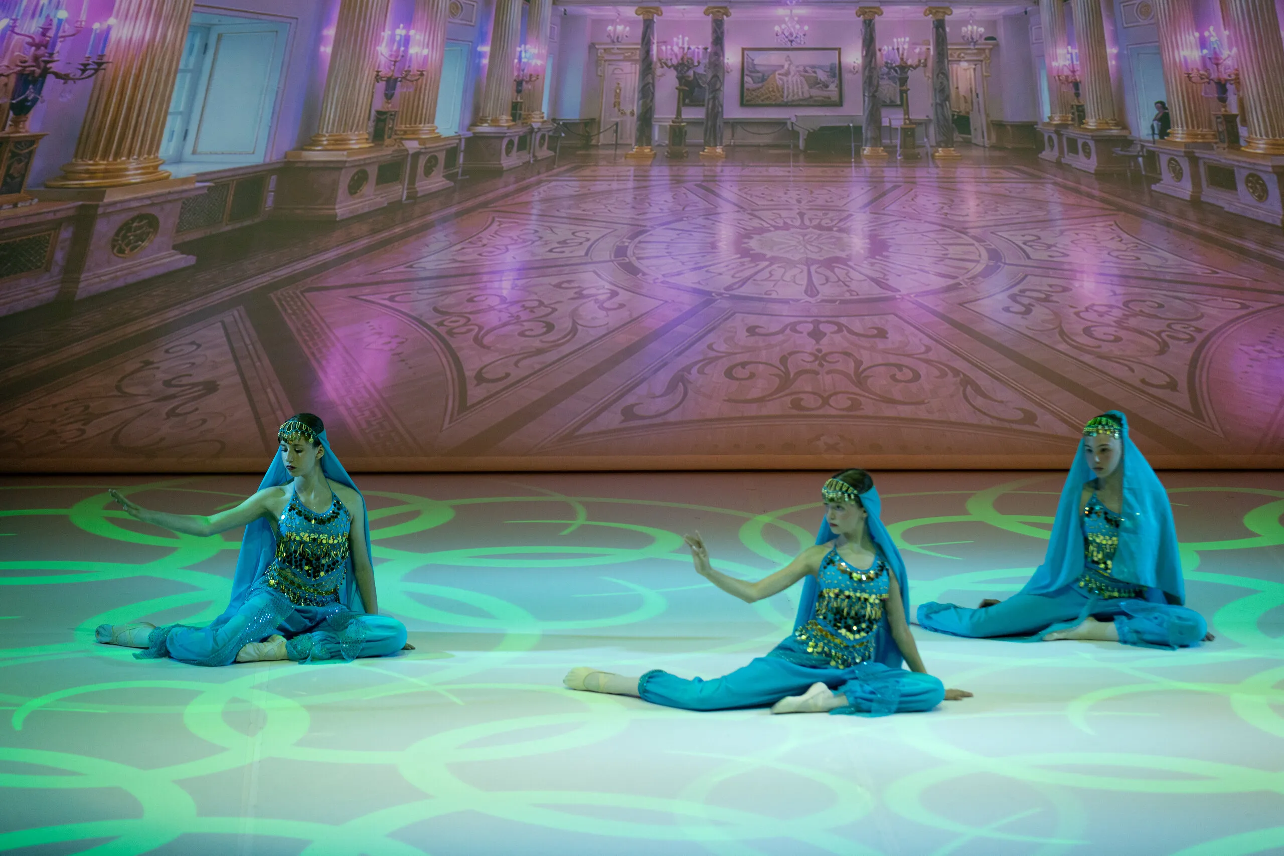 La danse arabe, trois élèves en bleu turquoise.