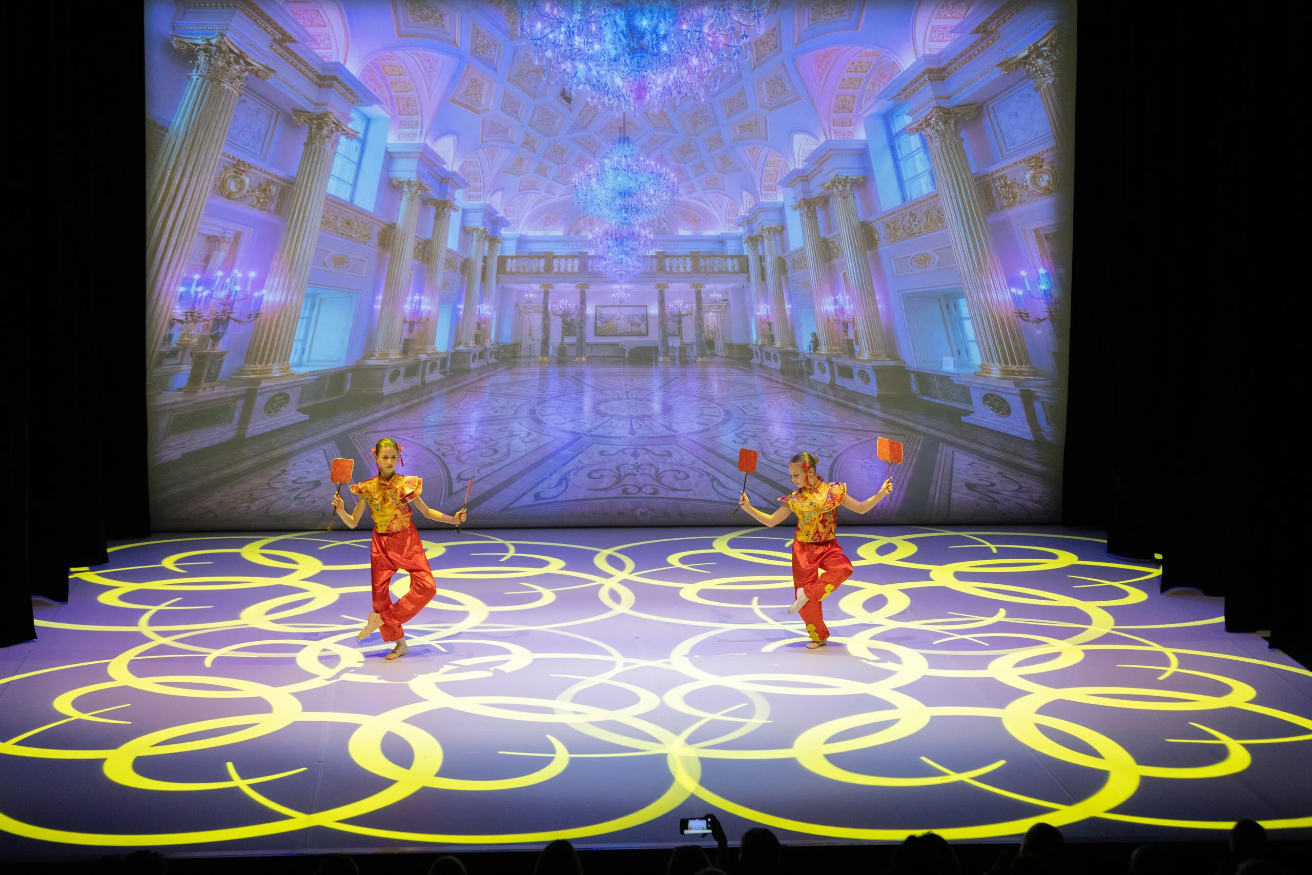 La danse chinoise, deux élèves en costumes rouge et or.