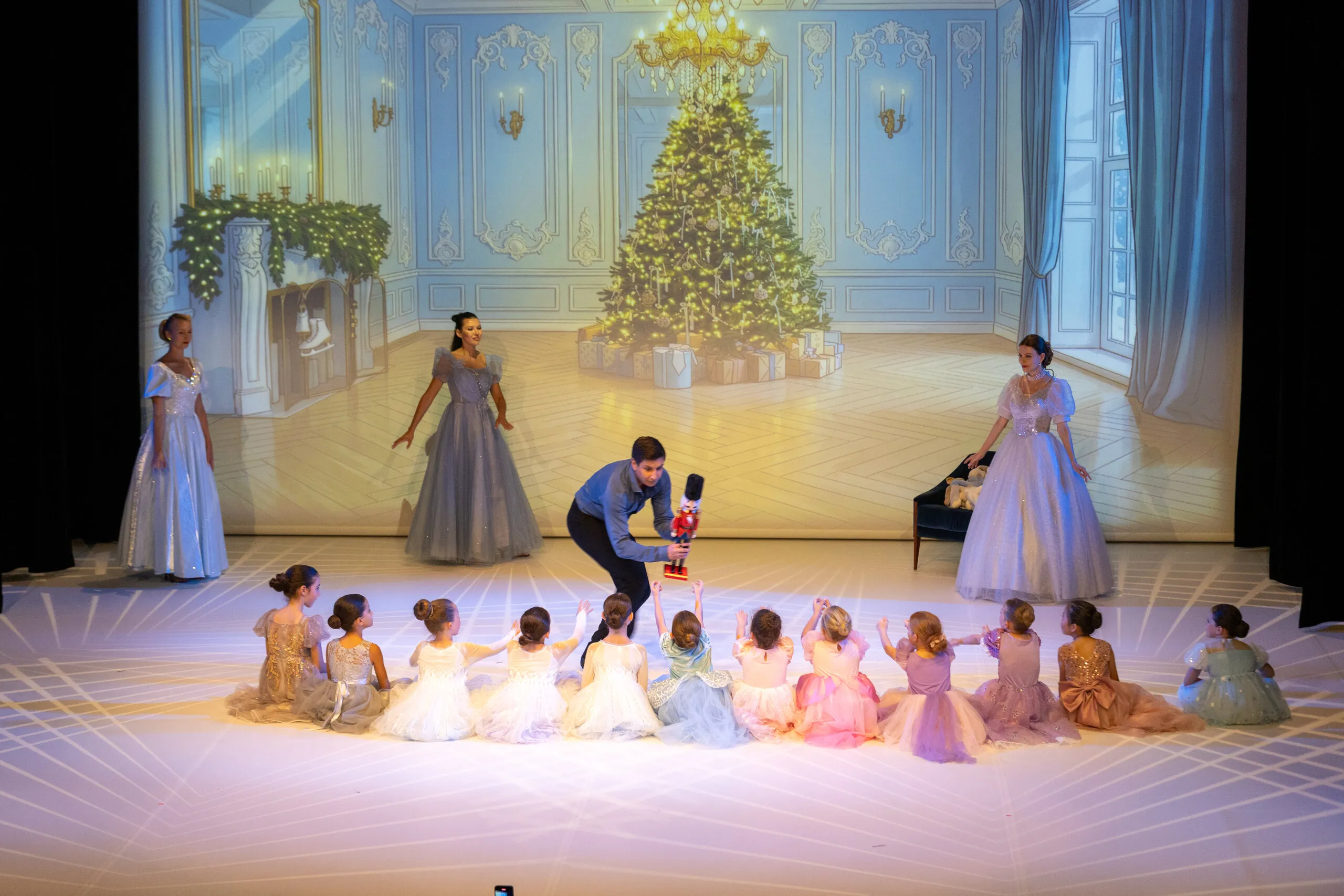 Enfants assis en demi-cercle, regardant la danse.