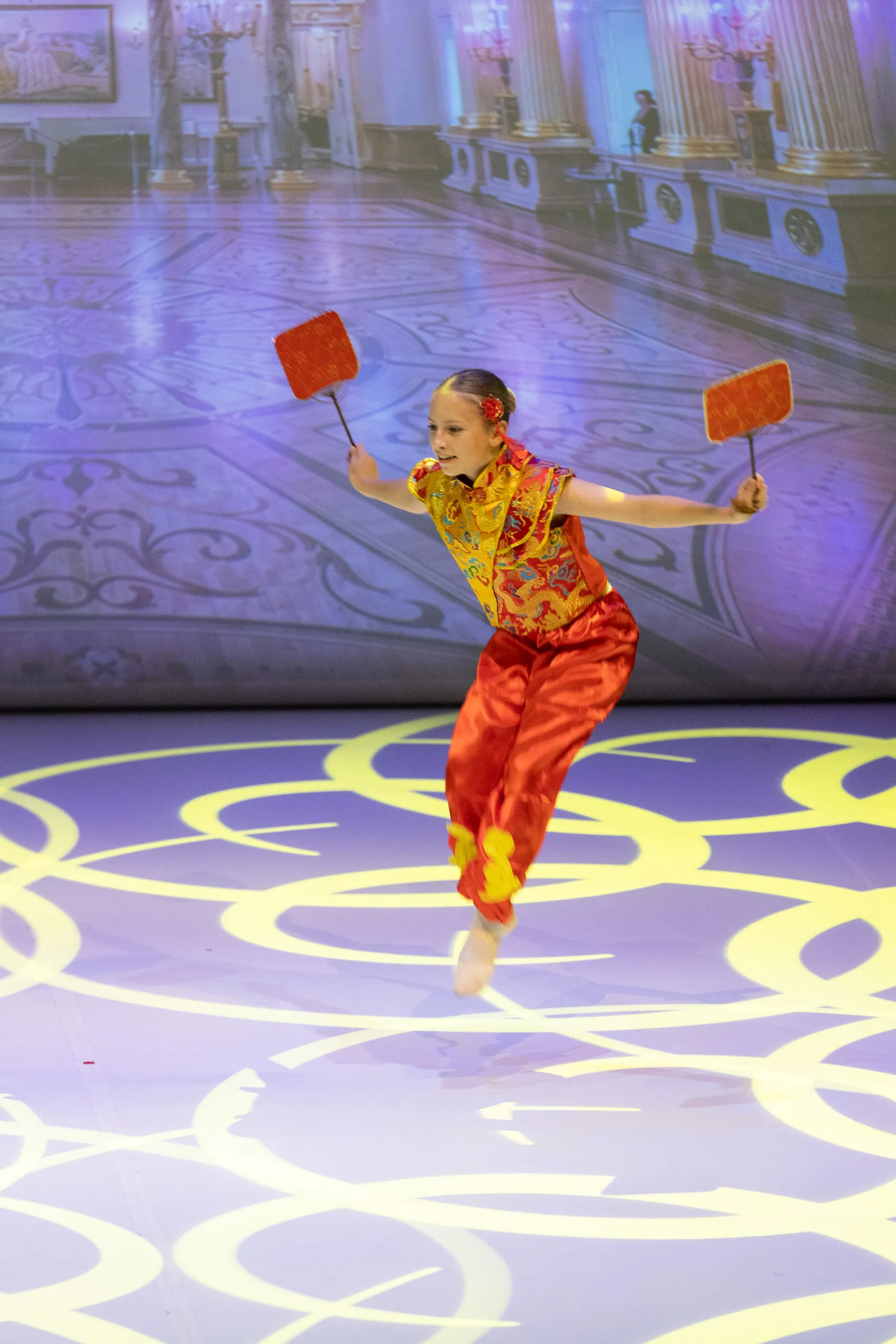 La danse chinoise, une élève en rouge et or, un éventail dans chaque main.