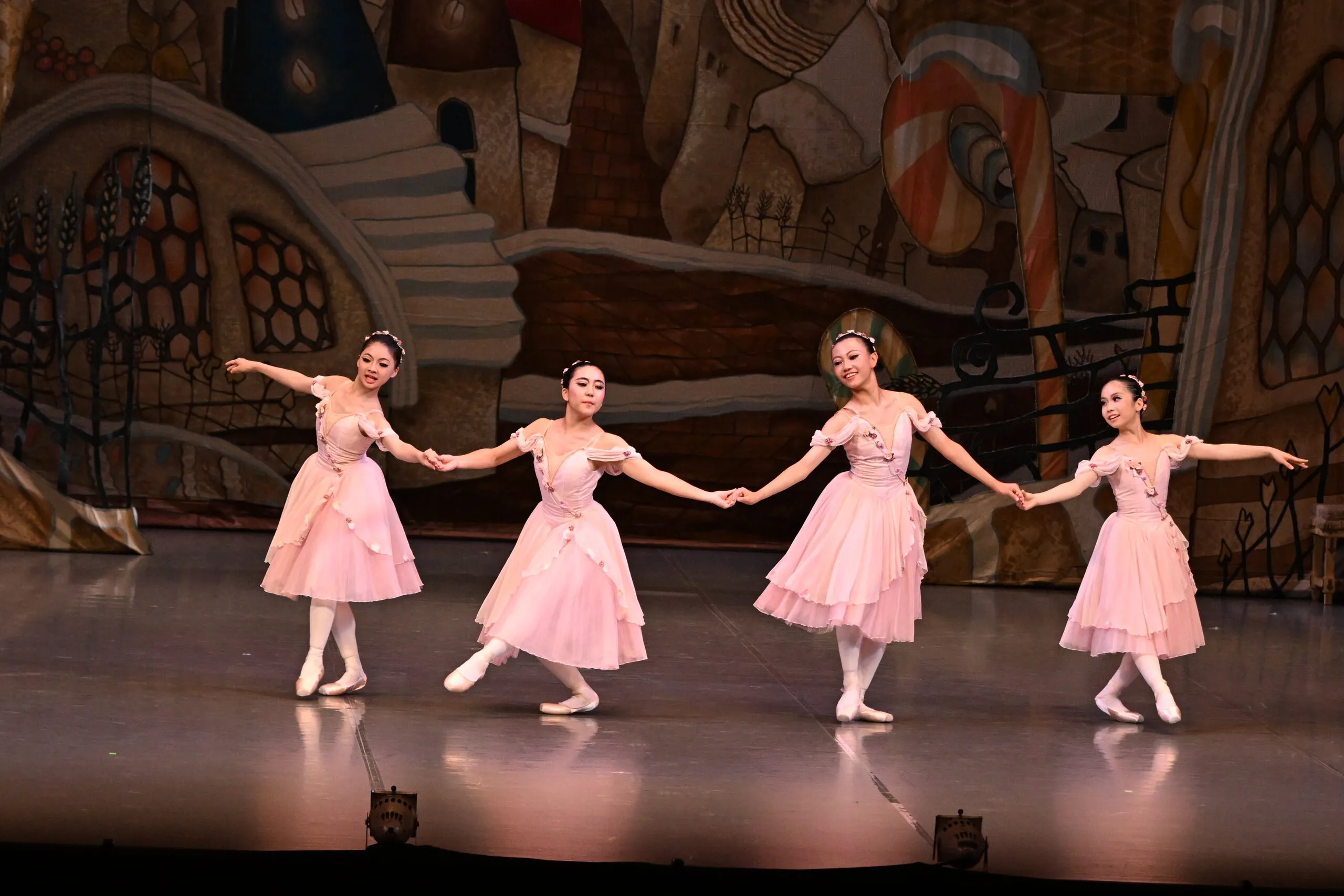 Quatre danseuses en ligne se tenant par la main.