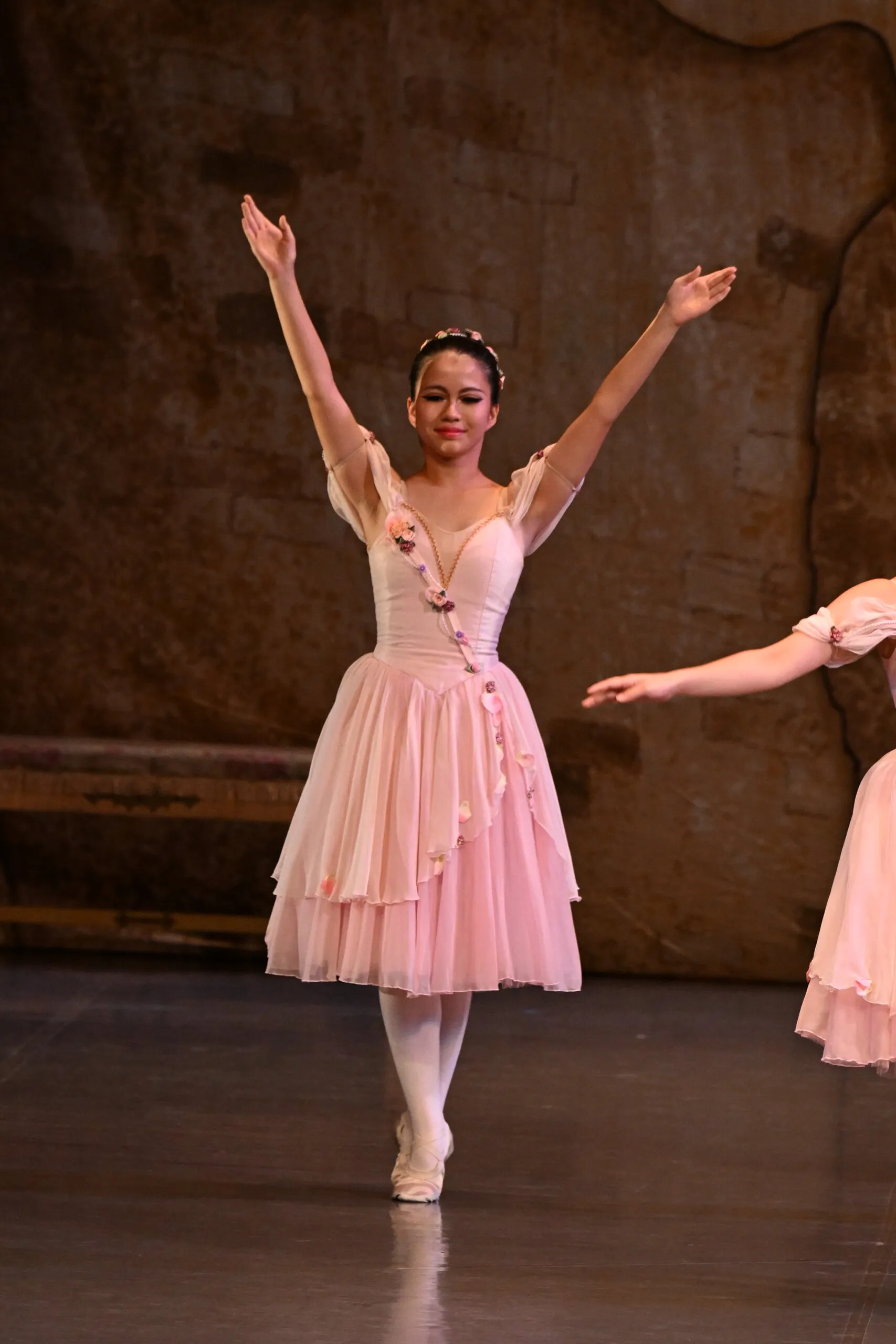 Une danseuse en costume de fleur, figure entière.