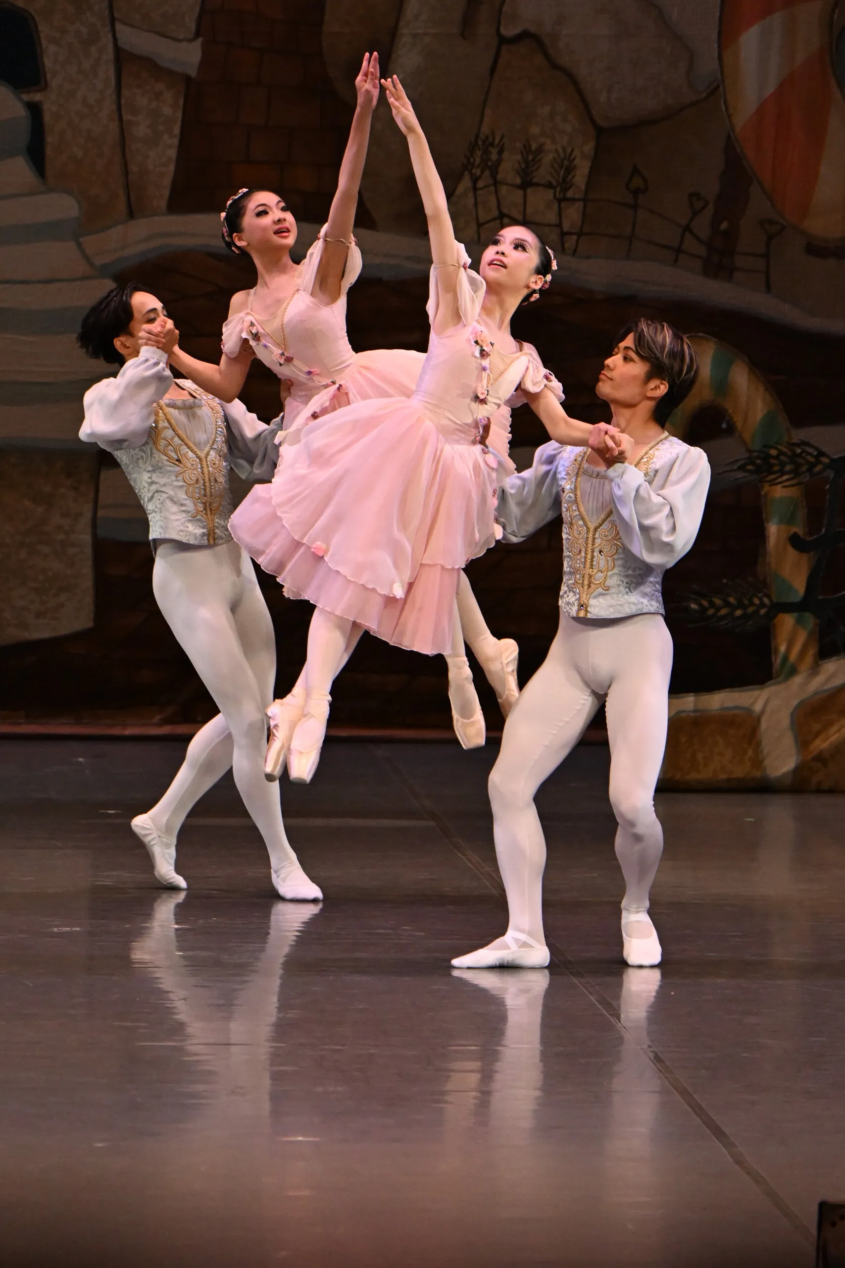 Groupe de quatre danseurs, la ballerine en rose au centre.