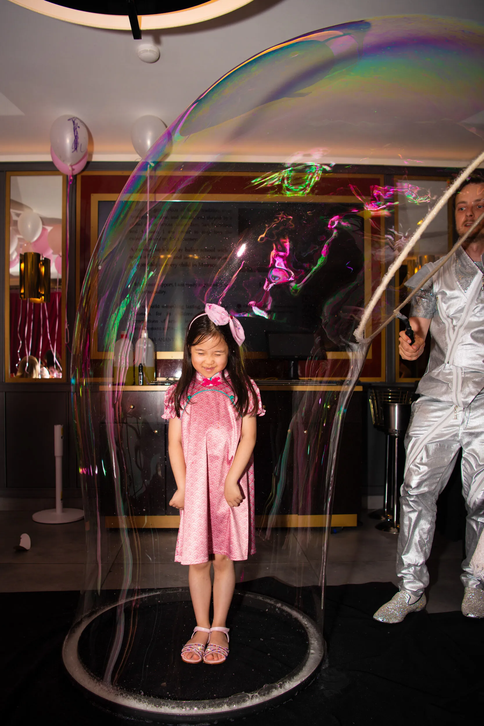 Une enfant ravie, debout au centre d'une bulle géante.