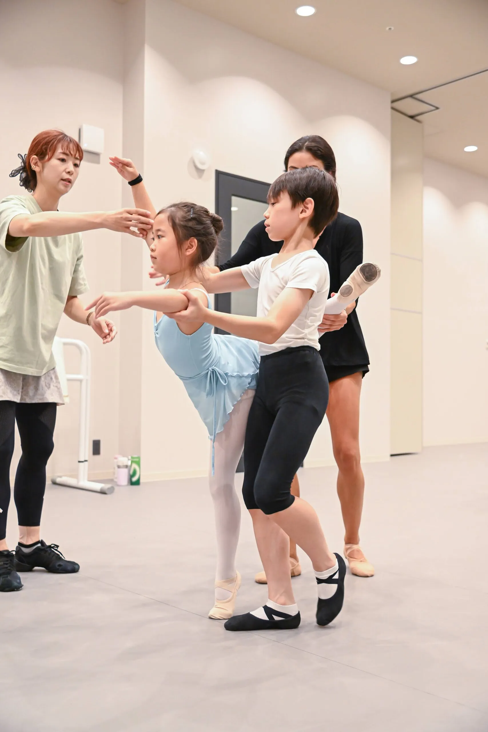 Deux professeures guident deux jeunes élèves dans un premier travail de pas de deux